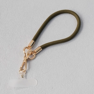 Détail du cordon de téléphone tressé vert olive avec fermoir mousqueton doré et insert