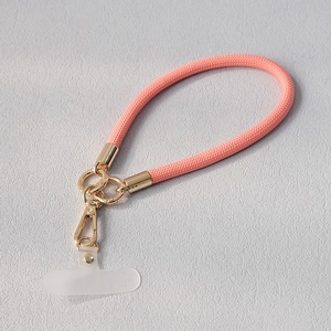Détail de la lanière de téléphone en nylon rose corail avec anneaux et fermoir dorés