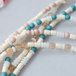 Macro shot of colorful acrylic beaded strap featuring pastel round and cylindrical beads