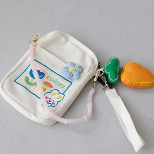 Close-up of white canvas bag with colorful rabbit embroidery and pink beaded strap