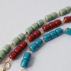 Macro detail of colorful acrylic resin bead chains with metallic gold connectors