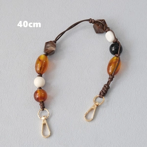 Detail view of 40cm acrylic beaded strap with amber beads and gold metal hooks