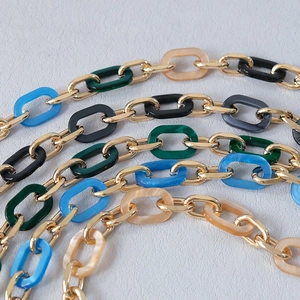 Detail of colorful marble resin links combined with gold metal rings for handbag straps