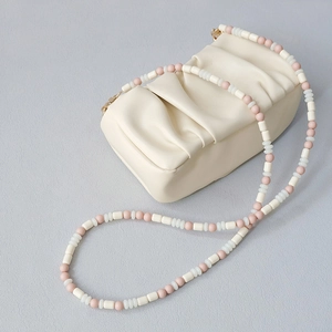 Chic creamy white cloud bag with pink and white beaded shoulder strap in cross-body style