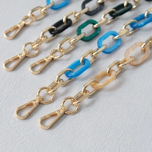 Detail of colorful acrylic resin rings with gold metal loops and lobster clasps for handbags