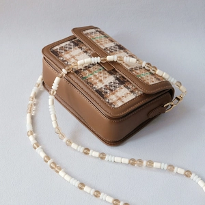 Brown checkered crossbody bag with unique acrylic bead strap and gold metal hardware