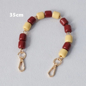 Detail view of 35cm beaded chain strap with red and yellow resin beads and gold lobster clasps