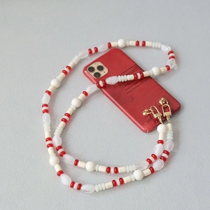 Detail of candy-colored acrylic beaded phone strap with golden spring metal clasps