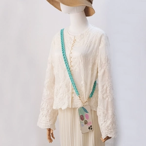 Detail of floral iPhone case with mint green crossbody woven rope and gold metal clips