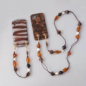 Close-up of acrylic beaded lanyards with zebra and tortoise shell pattern phone cases