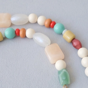 Detailed macro view of colorful resin beads chain with marble textures and vibrant hues