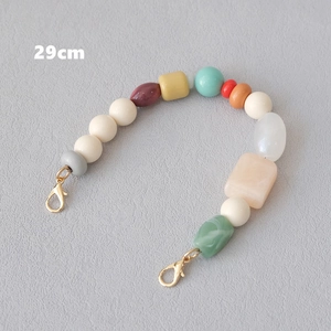 Detail of 29cm colorful resin beaded bag chain with lobster clasps on gray background