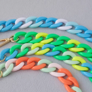 Close-up of colorful acrylic fishbone phone chain with gold lobster clasp