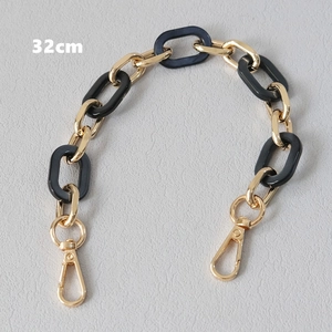 Detail of 32cm bag strap chain with alternating gold metal rings and black resin links