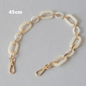 Detail view of 45cm cream acrylic chain strap with gold metal rings and lobster clasps