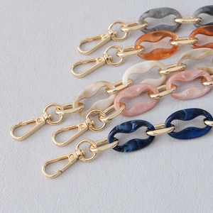 Detailed close-up of acrylic marble resin bag chains with gold lobster clasps in various colors