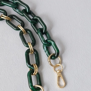 Detail of dark green marble resin chain strap with gold metal spring swivel clasps