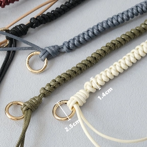 Close-up of woven handbag straps in four colors with gold metal ring buckles