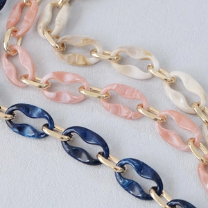 Detail of acrylic resin chain straps with marble textures in blue, pink, and cream colors