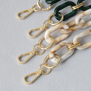 Detail of acrylic marble beige and green chunky bag straps with gold metal lobster clasps