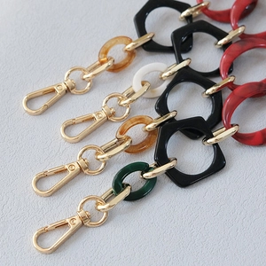Close-up of resin acrylic handbag chains with gold metal lobster clasps in various colors