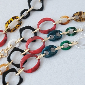 Close-up of leopard and marble acrylic resin purse straps with gold metal clasps