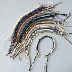 Detail of multi-color woven wax rope handbag straps with polished gold metal rings