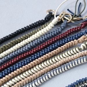 Close-up of colorful braided wax rope bag straps with elegant golden ring clasps