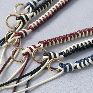 Detail of woven leather rope bag straps with gold metal rings for shoulder bags