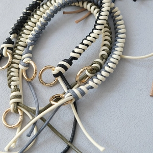 Detail of woven wax rope handbag chains with golden metal rings in various colors