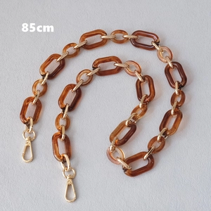 Detailed view of 85cm amber acrylic and gold metal chain strap with lobster clasps