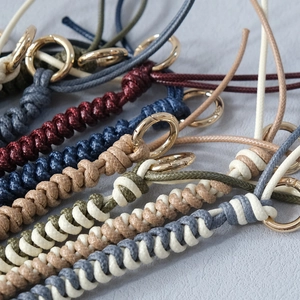 Close-up of colorful braided wax rope bag chains with golden round metal clasps