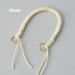Close-up of 35cm cream woven bag handle with golden round spring buckles for handbags