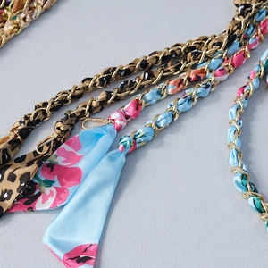 Detail of woven gold metal chain strap with leopard and floral print silk scarf