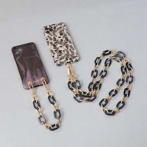 Detailed view of floral and marble phone cases with resin and gold metal link chains