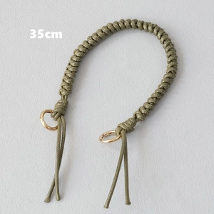 Detailed view of olive green 35cm braided wax rope handbag strap with gold metal rings