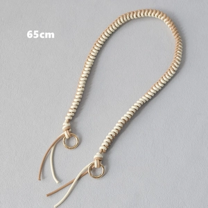 Detail view of 65cm hand-woven wax rope bag strap with golden rings in khaki and beige
