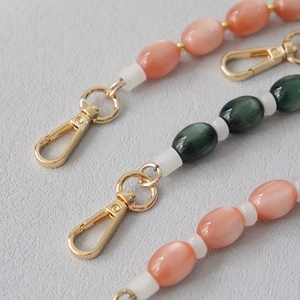 Detail of colorful resin beaded straps with gold lobster clasps for bags and phones