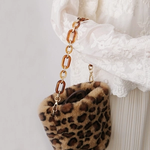 Detail of leopard print faux fur bag with thick amber acrylic chain strap and lace outfit