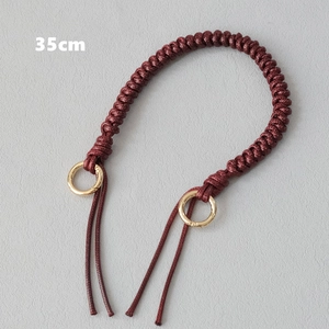 Detailed view of a 35cm braided wax rope handbag handle in wine red with gold metal rings
