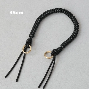 Detail of 35cm black wax rope woven handbag handle with golden metal rings