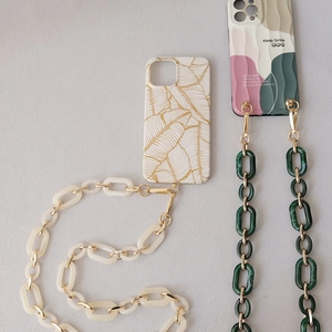 Detail of acrylic chain shoulder straps on textured phone cases with leaf and wave patterns
