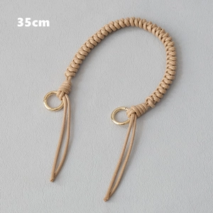 Detail of 35cm beige woven handbag strap with gold metal rings for fashion accessories