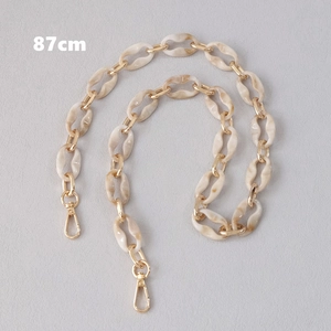 Detail of 87cm acrylic chain strap with cream marble links and gold lobster clasps