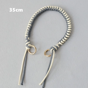 Detail of 35cm woven gray and beige rope handbag strap with gold metal ring buckles