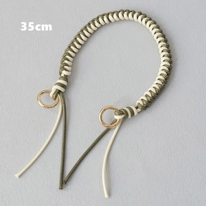 Detail of 35cm hand-woven green and cream wax rope bag strap with gold spring rings