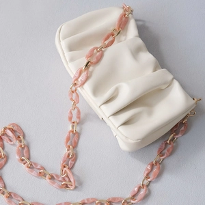 Detail of white dumpling bag with marble resin and gold metal chain strap links