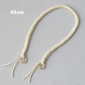 Close-up of 65cm cream woven rope bag strap with polished gold metal ring buckles
