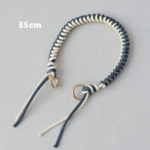 Detailed view of a 35cm blue and cream woven rope handle with gold circular metal clasps