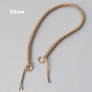 Close-up of a 65cm beige hand-woven cord strap with golden metal ring clasps